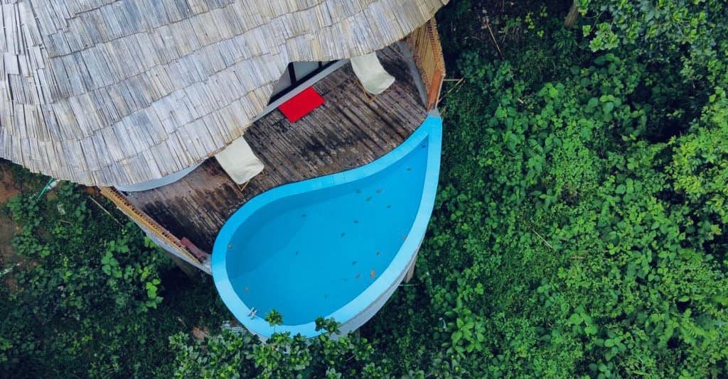 Aerial view of a thatched-roof villa with a private pool at Backyard Retreat