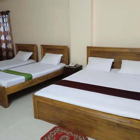 A twin-bed room at Cha Luxury Hotel & Restaurant with wooden beds and a maroon accent throw