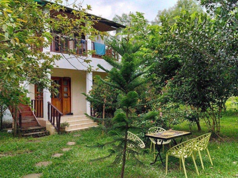 The two-storey building at Himkuri Bon Bungalow with a garden seating area