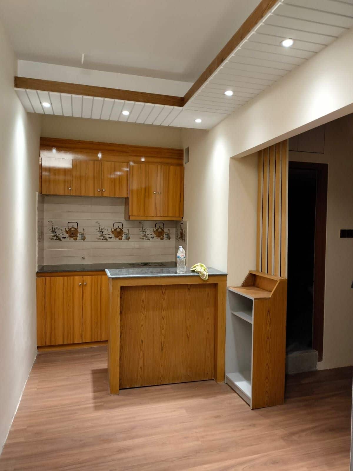 Hotel Taj Metro kitchenette with wood cabinetry and a breakfast bar