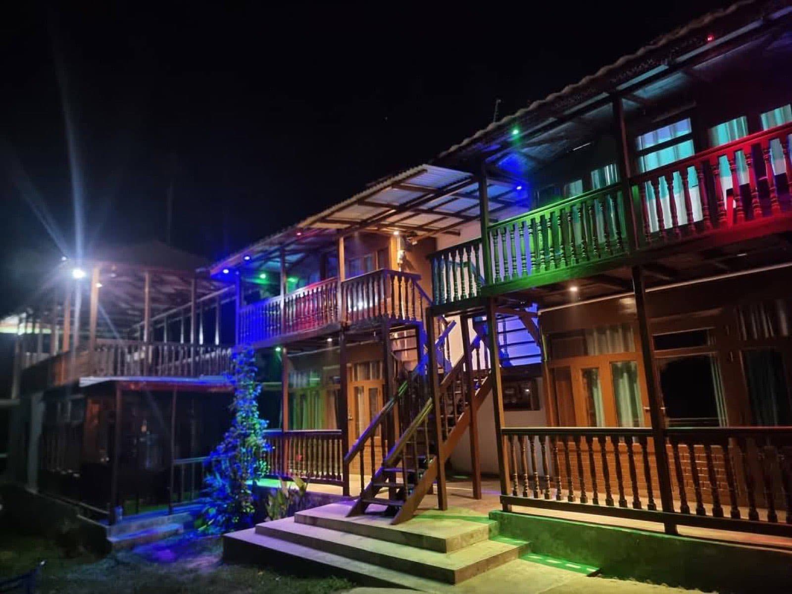 Ichche Bari Eco Resort's wooden balconies lit up with colourful lights at night