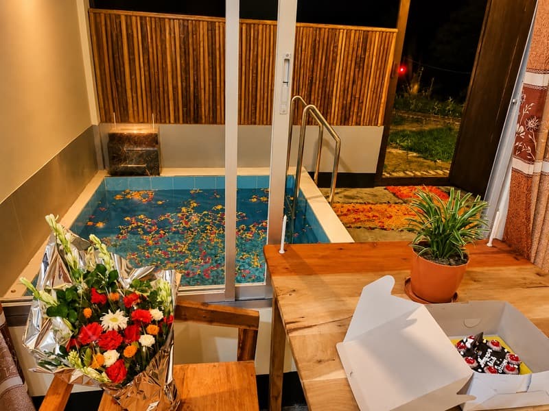 A private indoor plunge pool at Nirban Nibash Resort decorated with floating flower petals for a celebration