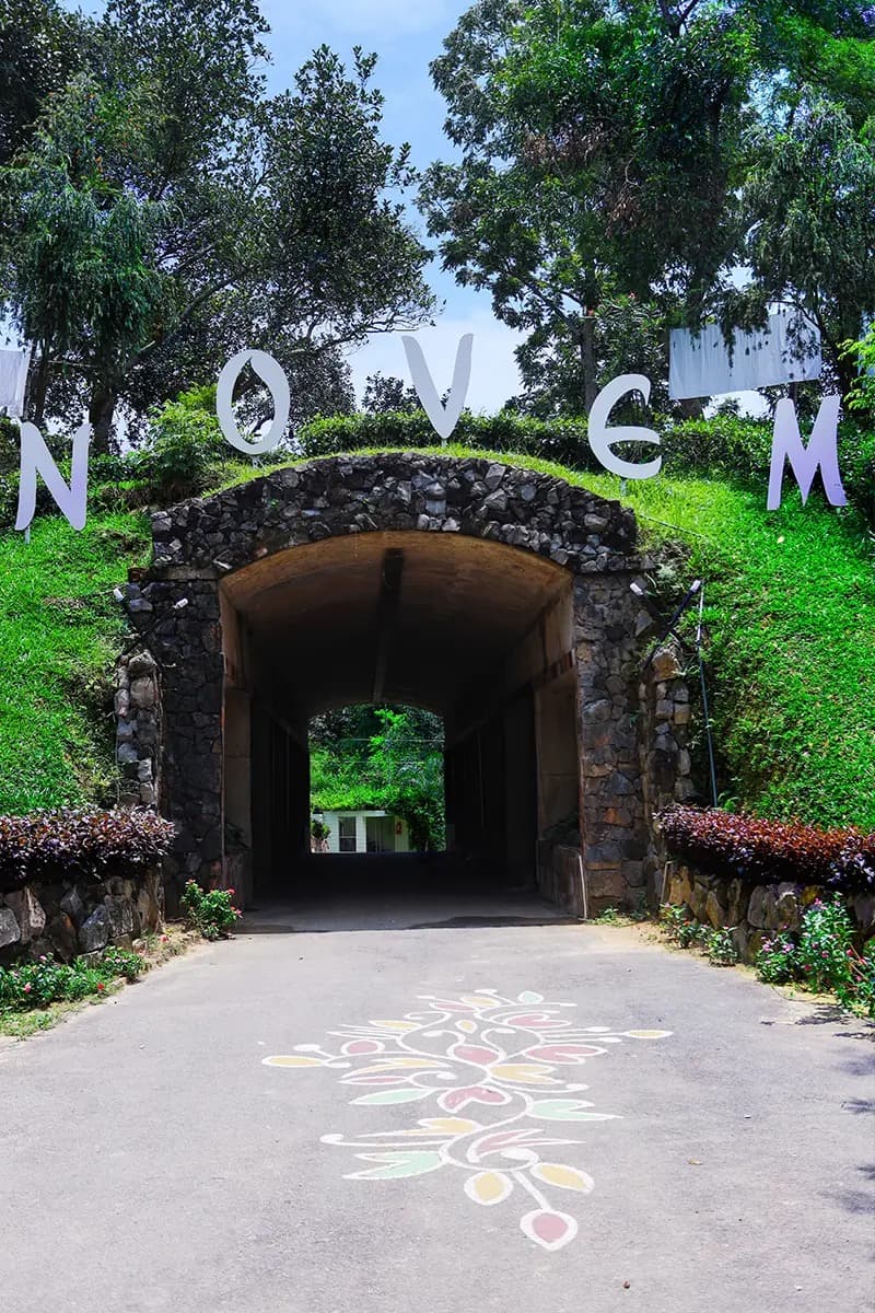 Novem Eco Resort's stone tunnel-gate entrance with giant 'NOVEM' lettering set into the hillside above it