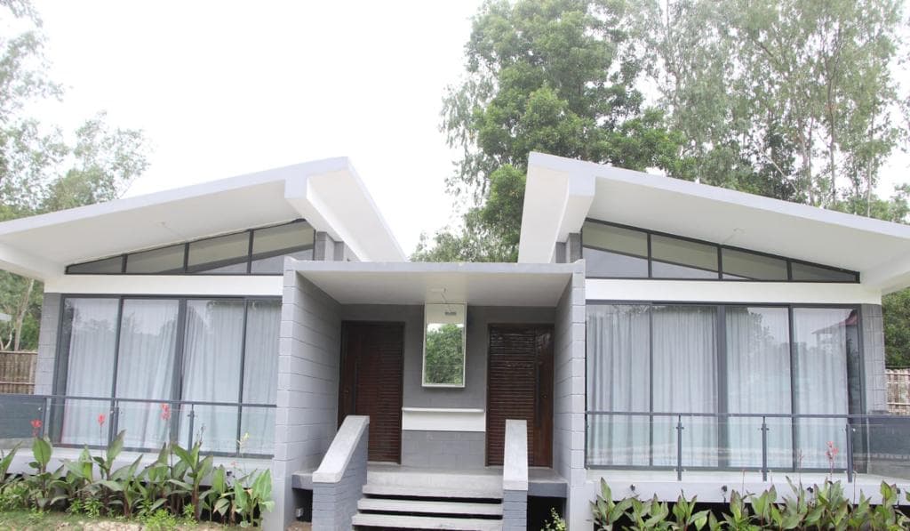Oronner Din Ratri Resort's twin butterfly-roofed cottage by daylight, the same building shown at dusk in the first photo