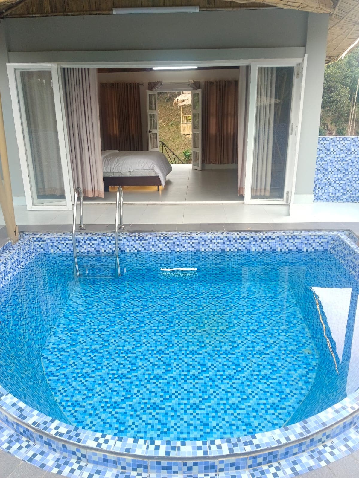Private mosaic-tiled swimming pool of the Pool Villa room, opening directly into the bedroom