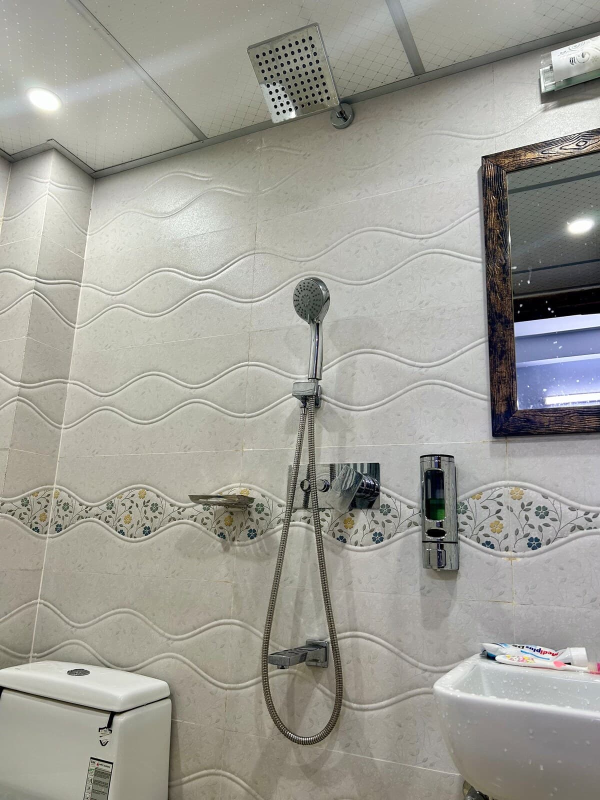 En-suite bathroom with rain shower, sink, and mirror at the private room near Sreemangal railway station