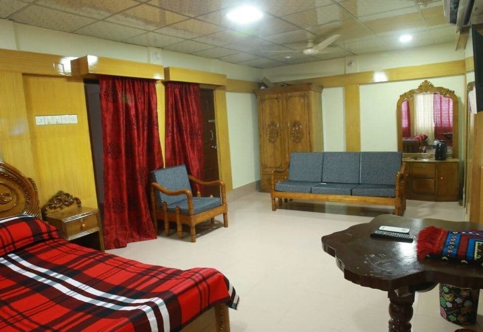 A spacious suite at Resort World with a sofa seating area, wooden wardrobe, and dressing table