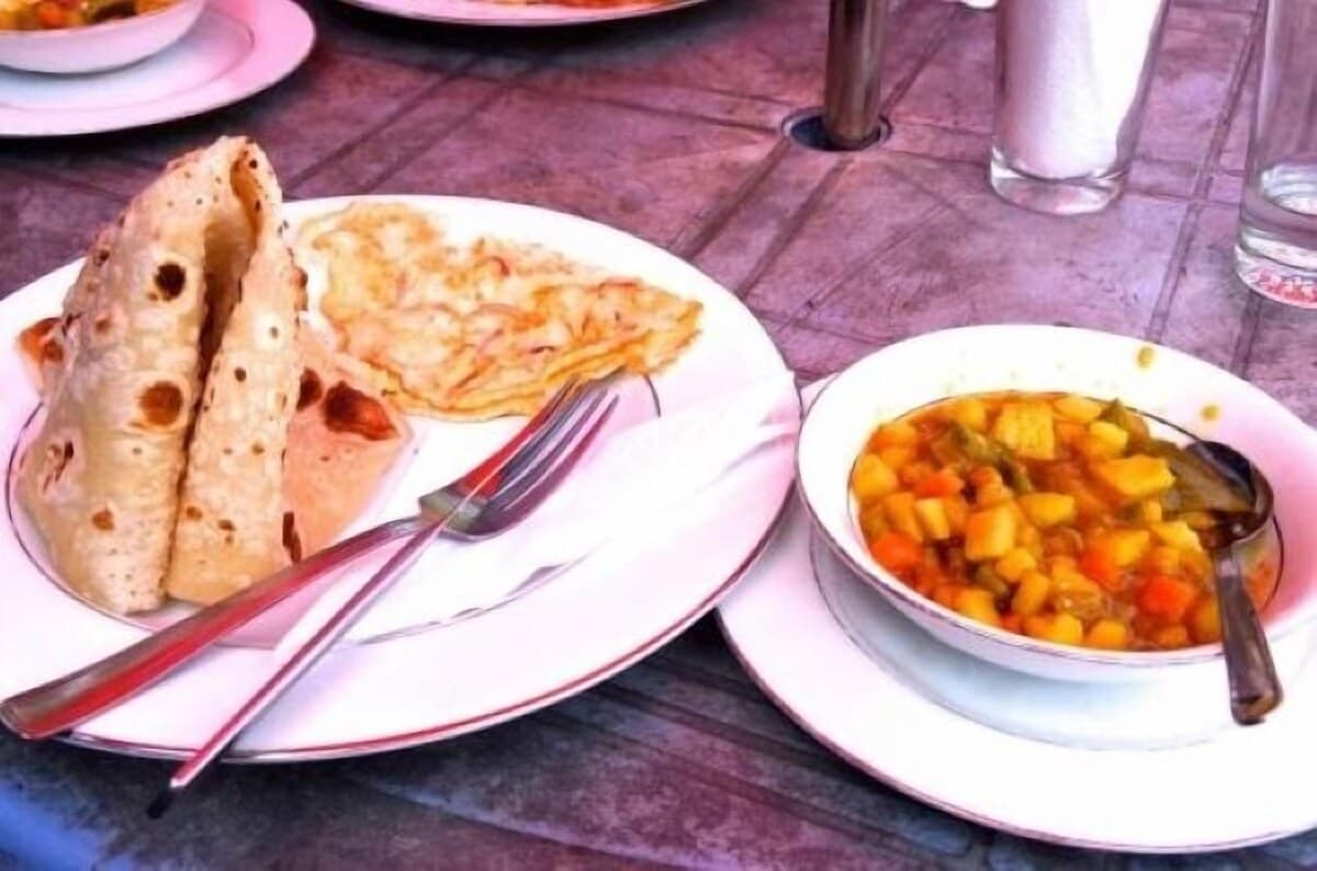 A breakfast spread of paratha, omelette, and mixed vegetable curry served at the property