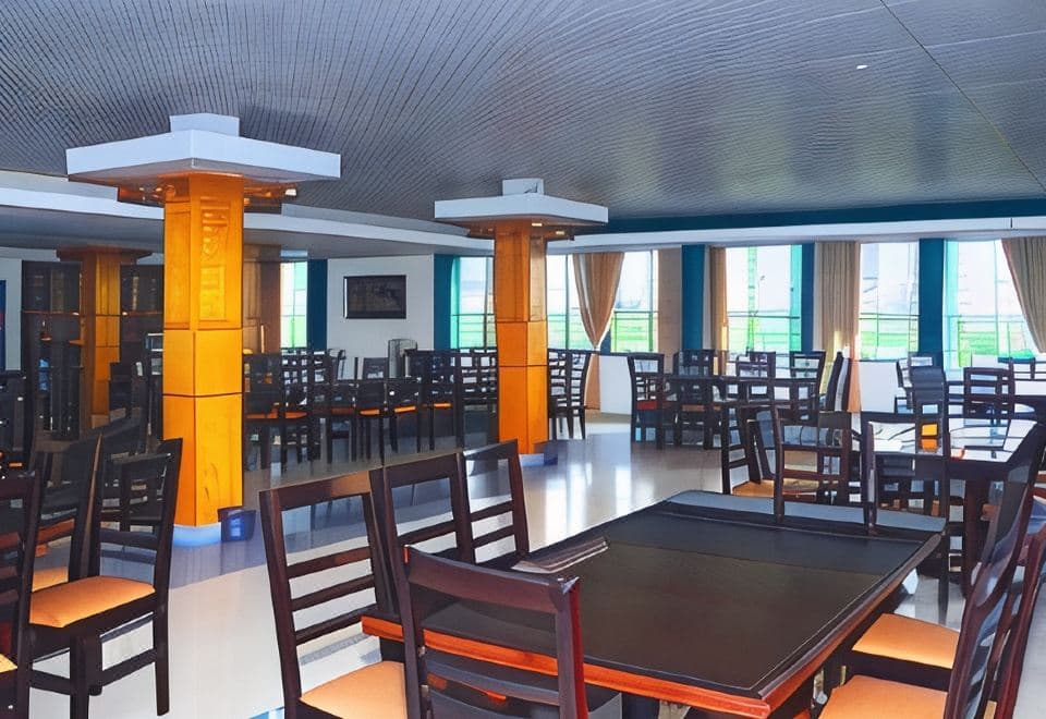 Tea Heaven Resort's dining hall with wood-panelled columns and rows of tables beside floor-to-ceiling windows